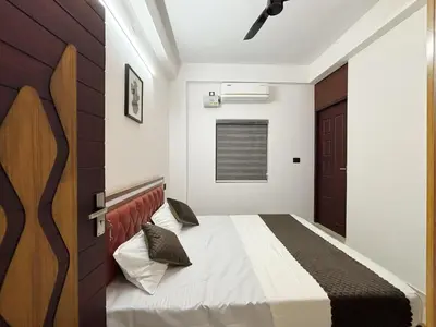 a bedroom with a bed and a wooden door at Lakshmi Home in Trichūr