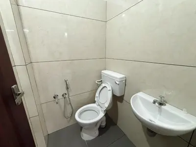 a bathroom with a toilet and a sink at Lakshmi Home in Trichūr