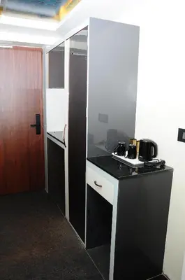 a small kitchen with a black counter and a stove at Vgrand in Ooty