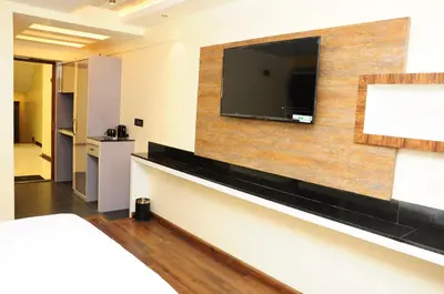 a hotel room with a flat screen tv on a wall at Vgrand in Ooty