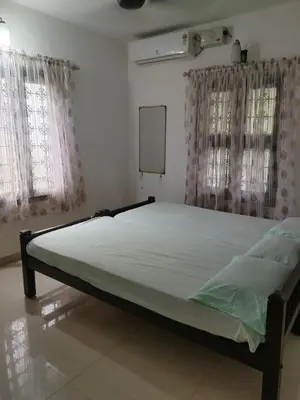 a large bed in a room with two windows at Thiruvambady Heritage Homestay in Trichūr
