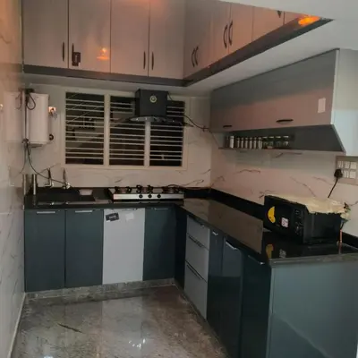 a kitchen with blue cabinets and a counter top at MVR Home Stay in Seringapatam