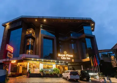 a building with a car parked in front of it at Royal Plaza Glitz Inn in Kozhikode