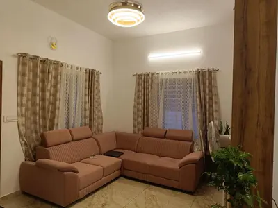 a living room with a brown couch and curtains at La- casona in Kottayam
