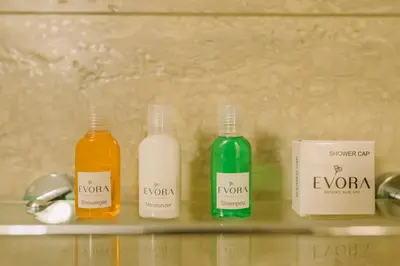 three bottles of soap and a box on a shelf at EVORA Resort and SPA in Ambalavayal