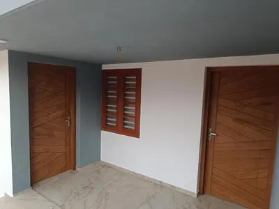 a room with two wooden doors and a wall at La casona in Kottayam