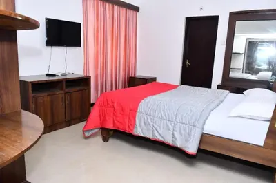 a bedroom with a bed with a red blanket and a mirror at Classic Homestay Hills Ooty in Ooty