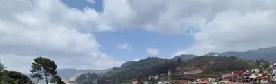 a town on a hill with houses and trees at Classic Homestay Hills Ooty in Ooty