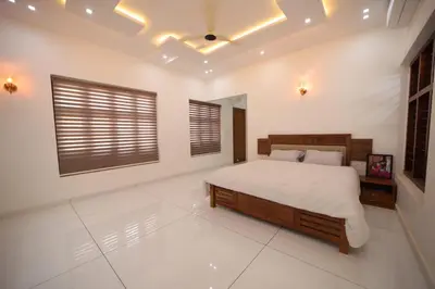 a bedroom with a large bed and a window at Village Pavilion in Tellicherry