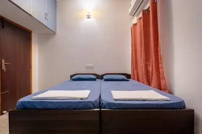 a bedroom with two beds with blue sheets at Meenakshi residency in Alāndurai