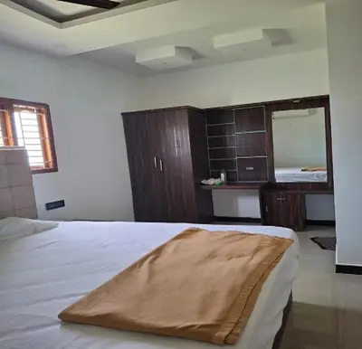 a bedroom with a large bed and a mirror at The Canalway Inn in Pollāchi