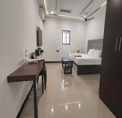 a bedroom with a bed and a desk in a room at The Canalway Inn in Pollāchi