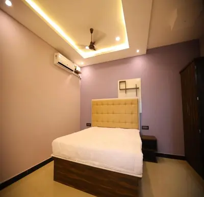 a bedroom with a bed in a room with purple walls at The Canalway Inn in Pollāchi