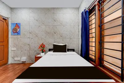 a bedroom with a bed and a window at Super Collection O Omni Bus Terminal Gandhipuram Formerly Apple Grand in Coimbatore