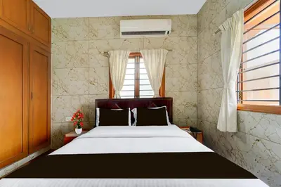 a bedroom with a large bed and a window at Super Collection O Omni Bus Terminal Gandhipuram Formerly Apple Grand in Coimbatore