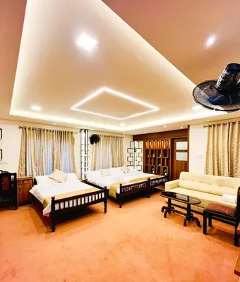 a large room with three beds and a couch at Joevilla-1BHK Near Kottiyoor in Kelakam