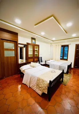 a hotel room with two beds in a room at Joevilla - 3BHK Near Kottiyoor in Kelakam