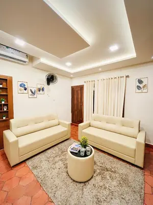 a living room with two couches and a table at Joevilla - 3BHK Near Kottiyoor in Kelakam