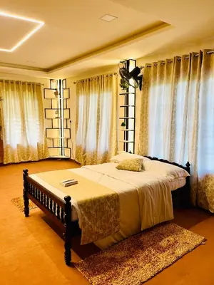 a bedroom with a large bed in front of windows at Joevilla - 3BHK Near Kottiyoor in Kelakam