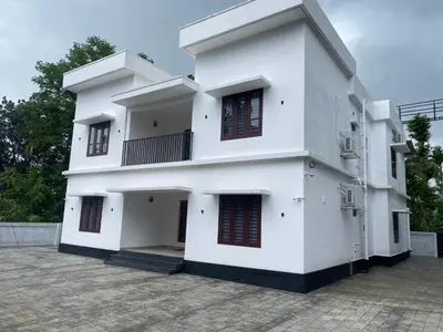 a white building with red doors and windows at Wayanad Mona Villa in Wayanad