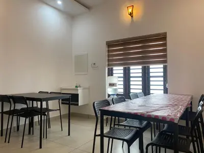 a dining room with tables and chairs and a window at Wayanad Mona Villa in Wayanad