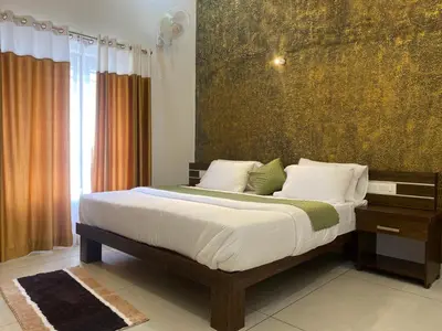 a bedroom with a large bed with white sheets at Wayanad Mona Villa in Wayanad