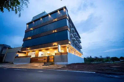 a building with lights on the side of it at Cross Roads Inn in Coimbatore