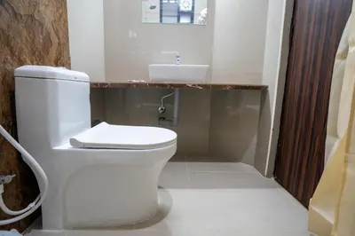 a bathroom with a white toilet and a sink at Cross Roads Inn in Coimbatore