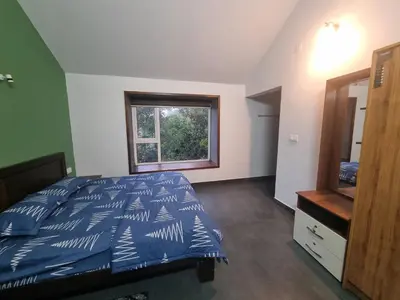 a bedroom with a bed and a window and a dresser at Eden Villa in Meenangadi