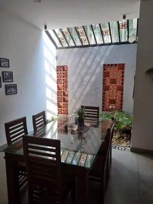 a dining room with a glass table and chairs at Eden Villa in Meenangadi