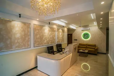 a lobby with a waiting room with a chandelier at DQ Premium Apartments in Ernakulam