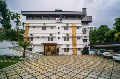 a large white building with a sign on it at DQ Premium Apartments in Ernakulam
