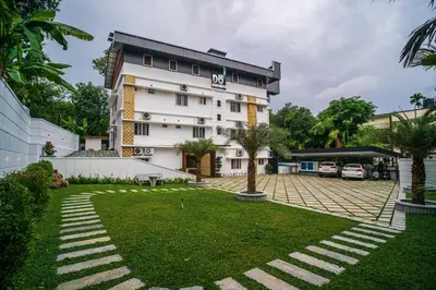 a hotel with a lawn in front of a building at DQ Premium Apartments in Ernakulam