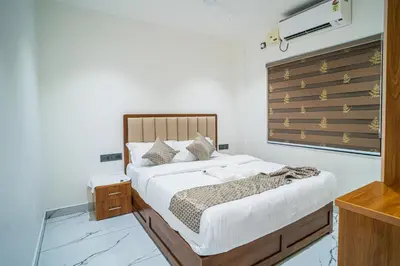 a bedroom with a bed with a wooden headboard at DQ Premium Apartments in Ernakulam