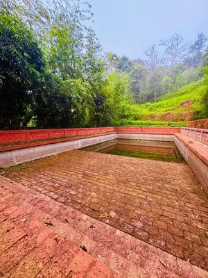 an empty brick patio with trees in the background at Vaca Vibes Resorts in Koroth