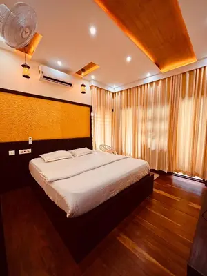 a bedroom with a large bed and a window at Vaca Vibes Resorts in Koroth