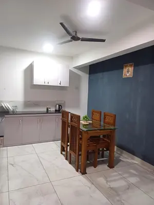 a kitchen with a table and chairs and a ceiling fan at Dream Stay Mukkam in Mukkam