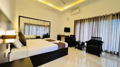 a hotel room with two beds and a desk at White Fort Holiday Home in Vythiri