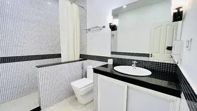 a white bathroom with a sink and a toilet at White Fort Holiday Home in Vythiri