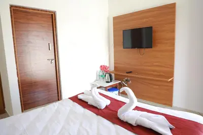 two swans sitting on a bed in a hotel room at Maitree Serenity Farm Stay