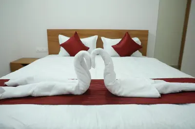 two swans shaped like hearts are laying on a bed at Maitree Serenity Farm Stay