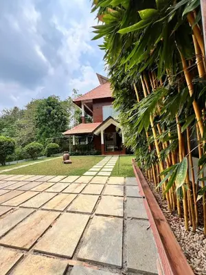a house with a stone walkway in front of it at Riverside Luxury Private Pool Villa in Athirappilly in Athirappally