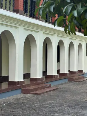 a building with arches on the side of it at Kerala Heritage Private Pool Villa - Tharavad in Māla