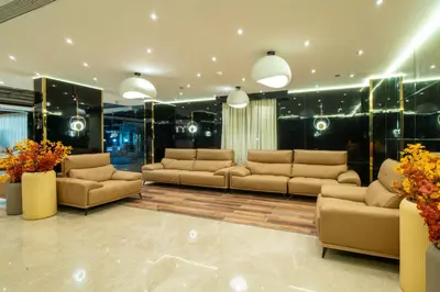 a living room with couches and tables and flowers at Senora Suites in Kannur