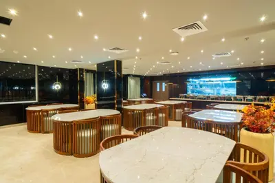 a restaurant with tables and chairs and a bar at Senora Suites in Kannur