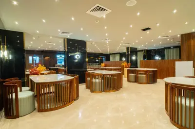 a restaurant with tables and chairs in a room at Senora Suites in Kannur