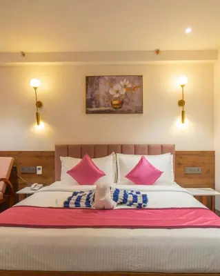 a child laying on a bed with pink and blue pillows at Senora Suites in Kannur