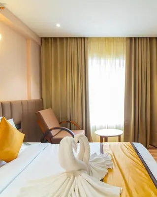 a swan decoration on a bed in a hotel room at Senora Suites in Kannur