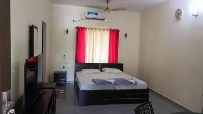 a bedroom with a bed and a red window at Jewel Homes Thattekad For birding and families - An ISO9001 ISO14001 ISO22000 Certified in Thattakād