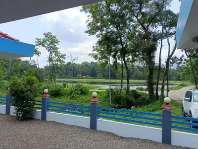 a blue fence with a view of a river at Jewel Homes Thattekad For birding and families - An ISO9001 ISO14001 ISO22000 Certified in Thattakād